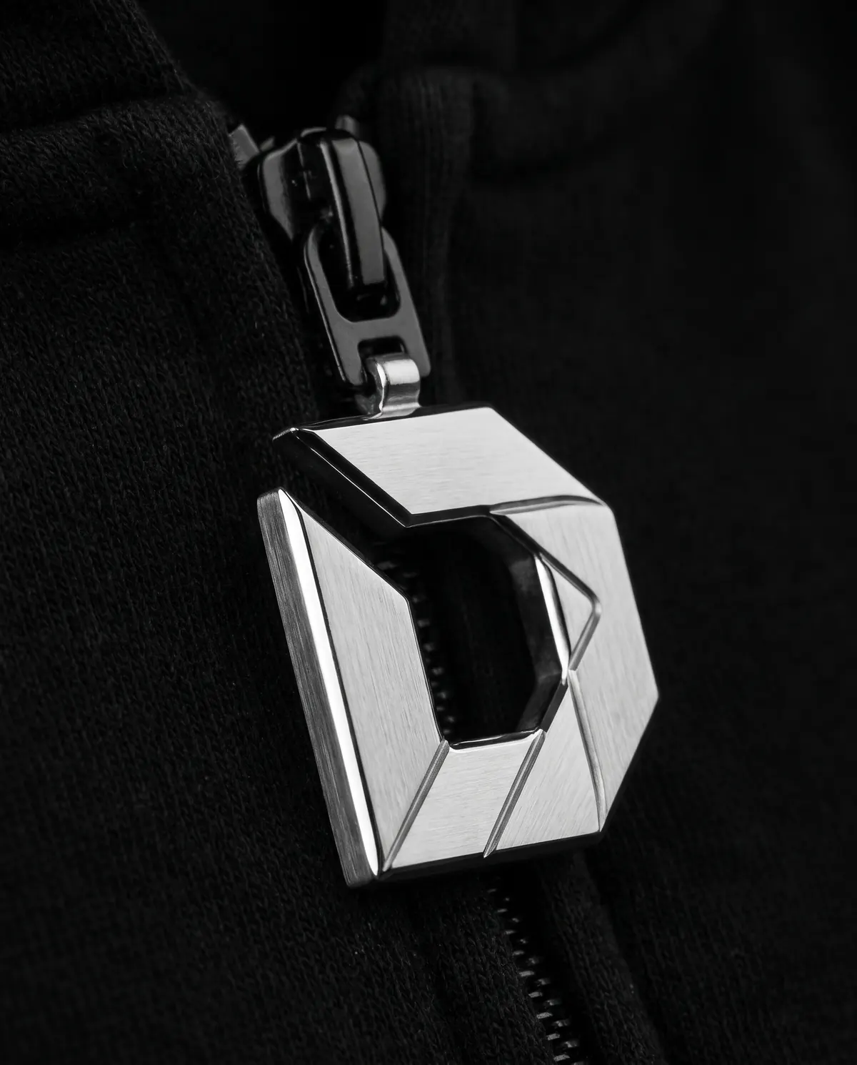 Close up of the zip hoodie: the zip pull, in stainless steel.