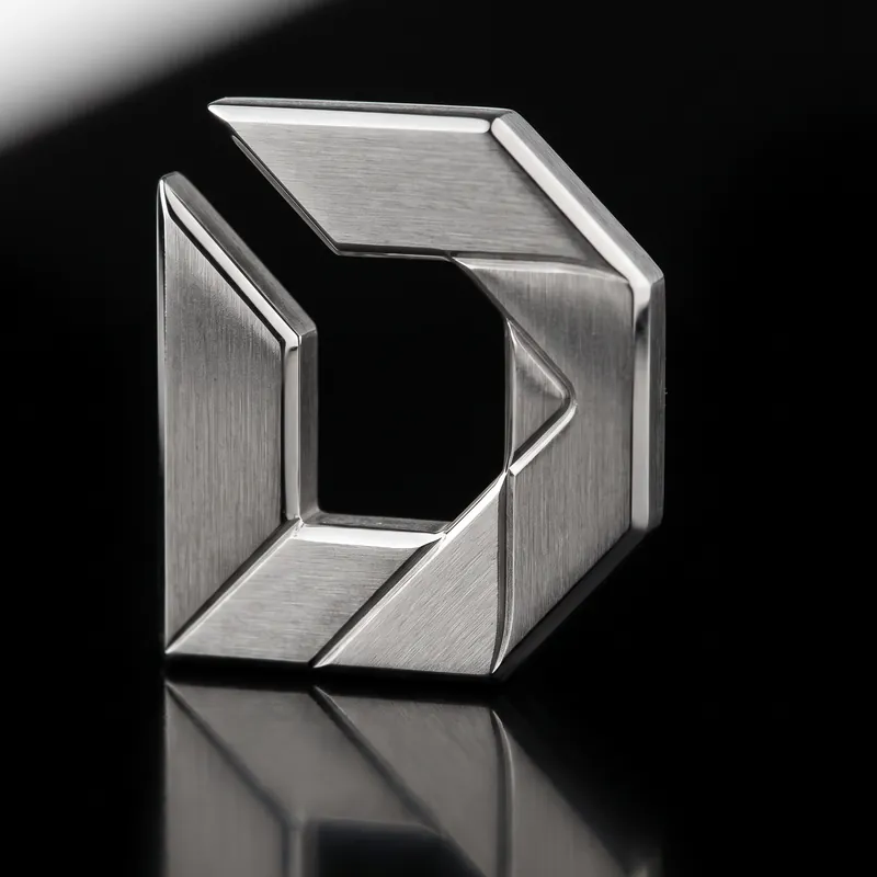 The Drook D machined from brushed stainless steel, standing on black acrylic.